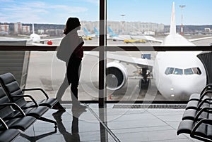 Silhouette of a tourist girl in the airport terminal