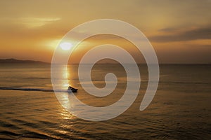 Silhouette of tourists riding a jet ski