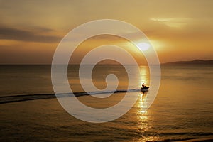 Silhouette of tourists riding a jet ski in the sea