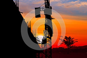 Silhouette Tower crane construction work on sunset-sunrise time background and copy space add text