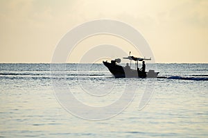 Silhouette traditional fisherman going to catch fish at early morning with his boat