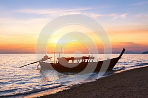 Silhouette of a traditional long-tail boat, beach, sunset