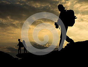 Silhouette traveller with camera and the couple on the rock at s