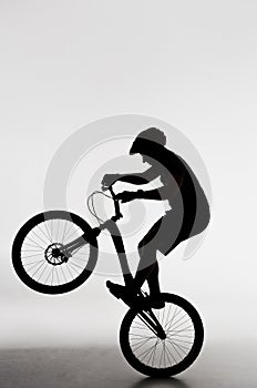 silhouette of trial biker standing on back wheel