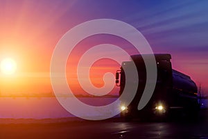Silhouette Truck with container on highway, cargo transportation concept. Sunset background with copy space