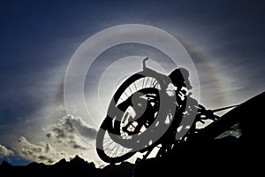 Silhouette of two bikes against a solar halo, Norway