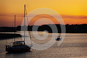A silhouette of two boats against an orange sky in South Carolina. photo