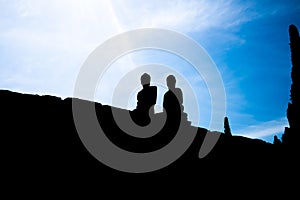 Silhouette of two Buddha statues