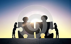 Silhouette of two business women connecting puzzle