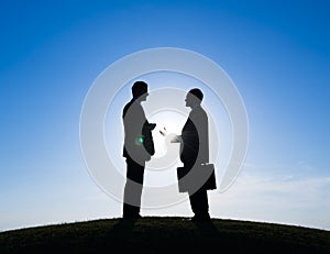 Silhouette of Two Businessmen Talking Together