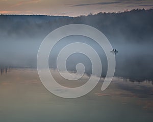 Silhouette of two fishermen on a boat at Spruce Knob Lake in the Monongahela Forest, West Virginia