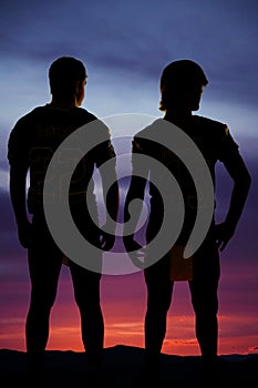 Silhouette of two football players standing