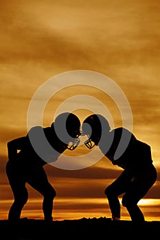 Silhouette of two football players in the sunset stand