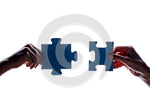 Silhouette of two hand holding couple of blue jigsaw puzzle piece on white background. concept - connection idea, sign, symbol, fr