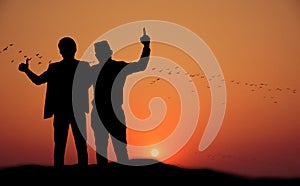 Silhouette of two happy people at sunset