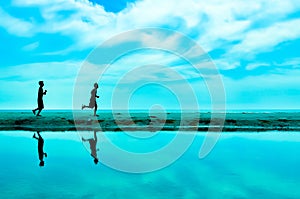 Silhouette of two man running at the beach