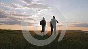 The Silhouette of two man on the top of mountain with Backpacks and other Gear expressing Energy and Happiness. Two