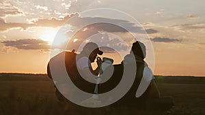 The Silhouette of two man on the top of mountain with Backpacks and other Gear expressing Energy and Happiness. Two