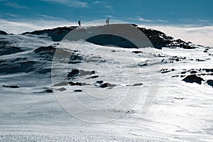 silhouette of two mountaineers on top of a snow-capped mountain, impressive copy space photograph