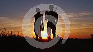 Silhouette of two people with tennis rackets in hands