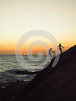 Silhouette of two rock climbers at sunset