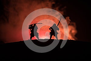 Silhouette of two samurais in duel. Picture with two samurais and sunset sky