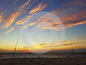 Silhouette of two surf fishing rods on the beach during early morning near Dewey Beach, Delaware, U.S.A