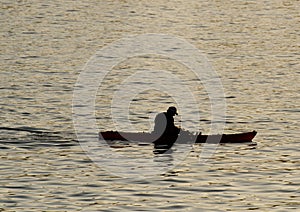 Silhouette of undefined kayaer on water at beautiful sunset time. Santa Cruz