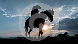 Silhouette of an unidentified man riding a horse in dusk