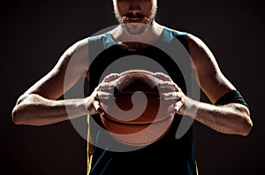 Silhouette view of a basketball player holding basket ball on black background