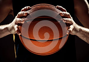 Silhouette view of a basketball player holding basket ball on black background