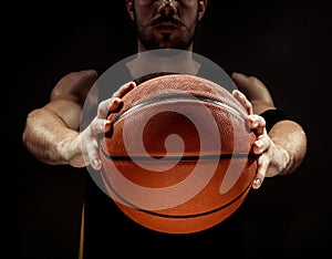 Silhouette view of a basketball player holding basket ball on black background