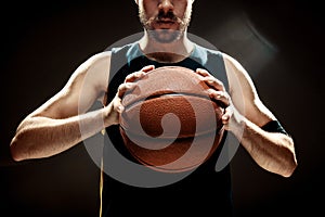 Silhouette view of a basketball player holding basket ball on black background