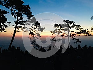 Silhouette view of crowd and colorful sky at peak mountain