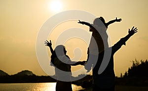 Silhouette view of happy family relaxing in park together on weekend