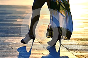 Silhouette walking women legs in backlight sunlight