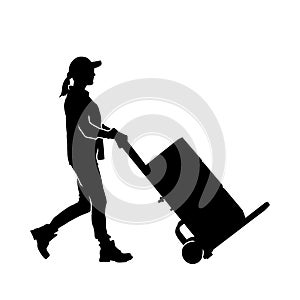 Silhouette of a warehouse worker female pulling a lori or trolley wheels full of boxes.