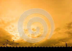 Sunset view. Roof, antenna, cloudy