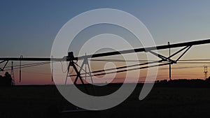 Silhouette of a water irrigation system on a farm in rural Georgia at sunset