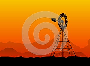 Silhouette of a water pumping windmill at the desert