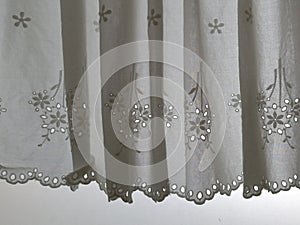 Silhouette White Lace satin curtain hanging on window with sunlight semitransparent behind, decoration interior room