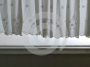 Silhouette White Lace satin curtain hanging on window and wall with sunlight semitransparent behind, decoration interior room