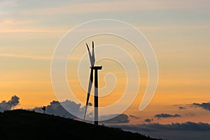 Silhouette wind generators turbines on sunset summer landscape i