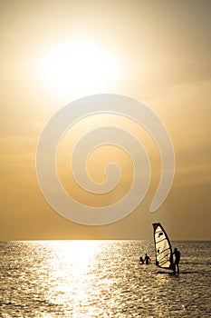 Silhouette of a wind-surfer on waves sunset