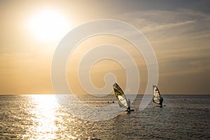 Silhouette of a wind-surfer on waves sunset