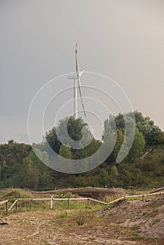 Silhouette of a wind turbine against a summer evening sky with c