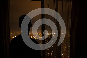 silhouette by window with cityscape nightlight