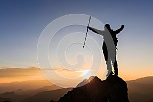 Silhouette woman backpacking travel atop a high rock, sports and active life concept, success