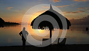 Silhouette of woman and beach umbrella