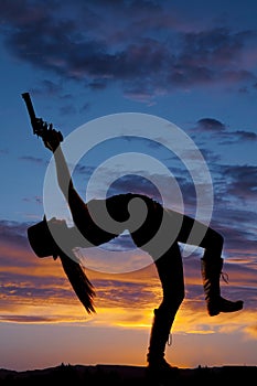 Silhouette woman bend back point gun up